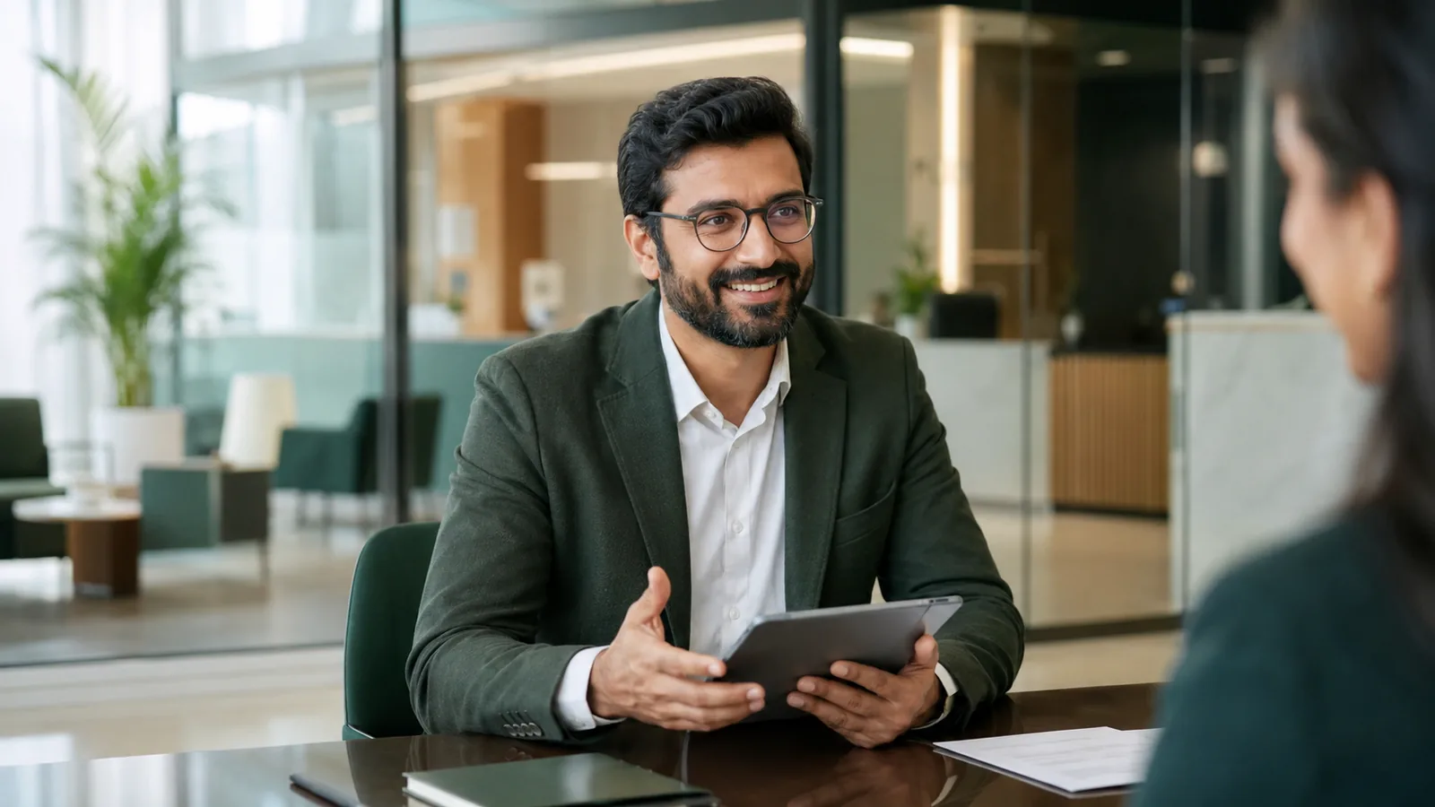 Consultor bancário conversando com um cliente e verificando um tablet